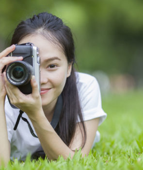 girl-with-camera-lie-down-on-grass